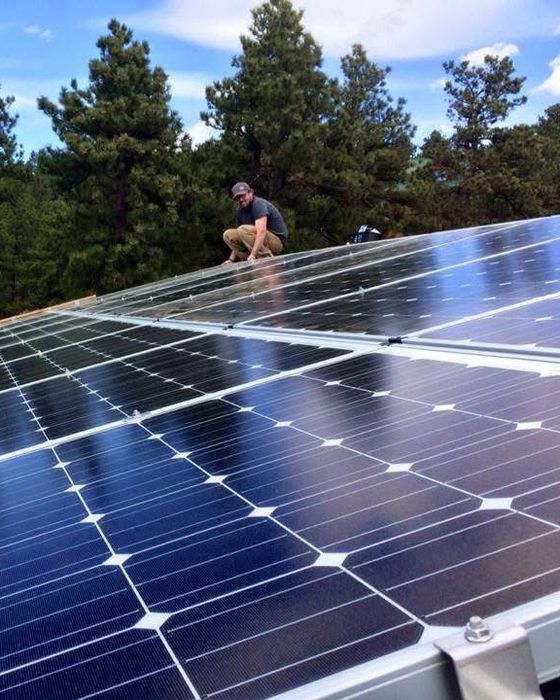 On the roof of a mountain home, installing a system on his father&rsquo;s house.